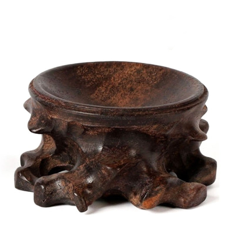 Close-up of Pau preto wood teapot stand highlighting textured surface and artistic stripe design