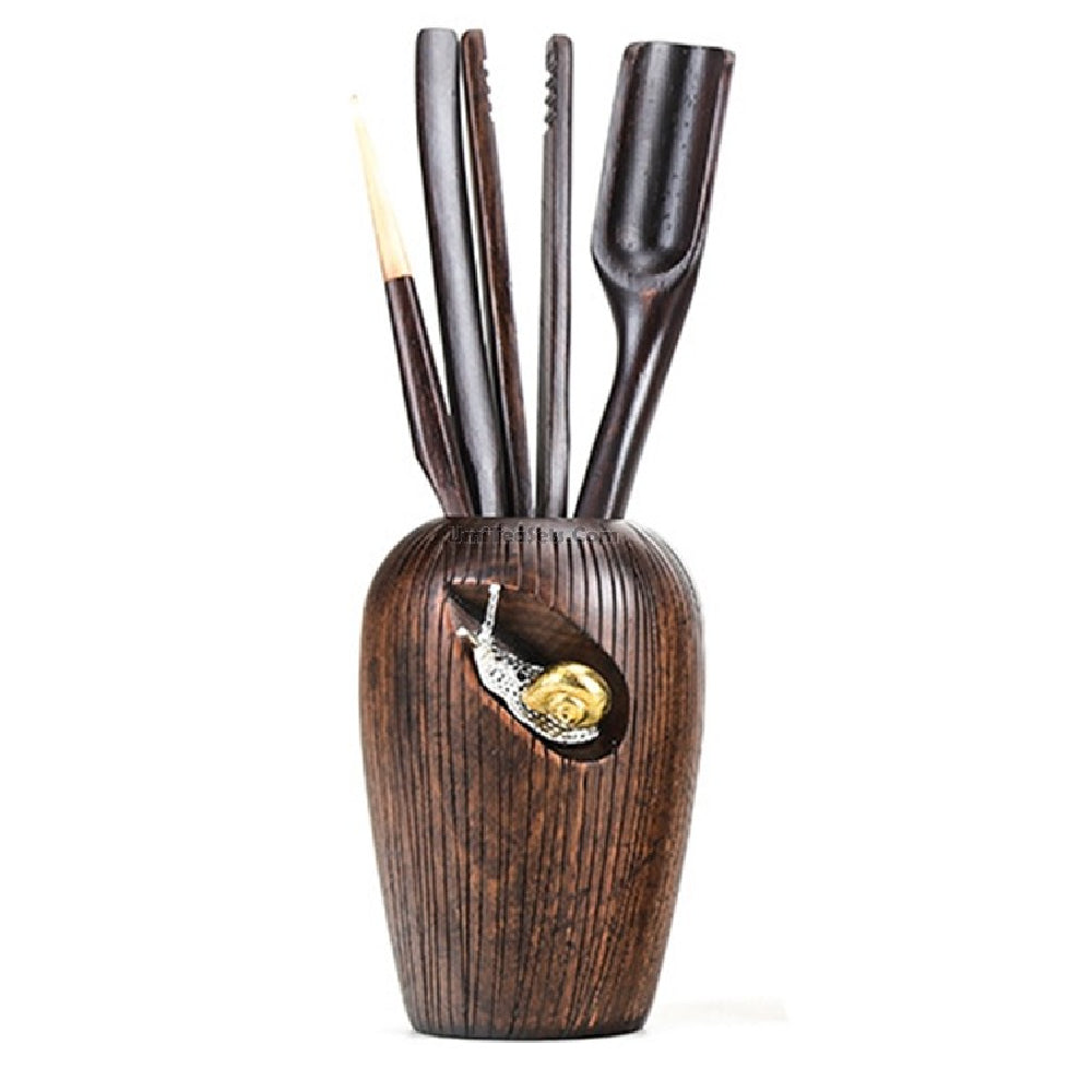 Elegant ebony wood tea utensil set displayed with tea brewing accessories.