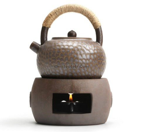 Close-up of a coarse pottery teapot with alcohol warmer showing intricate craftsmanship