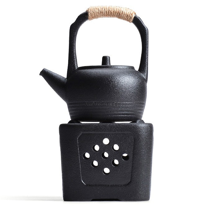 Front view of pottery teapot with alcohol warmer set on a wooden tray
