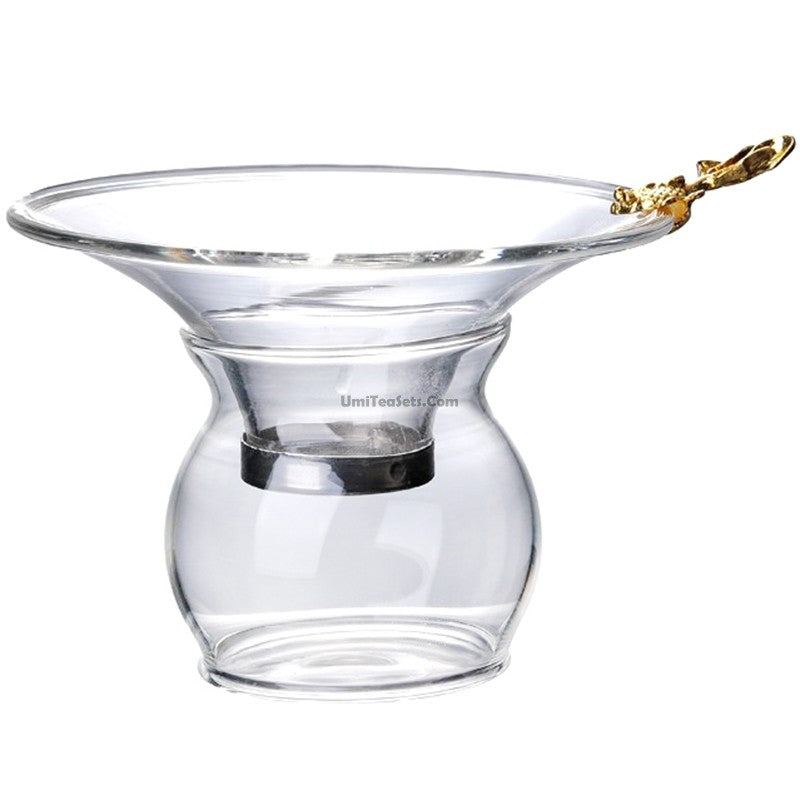Top-down view of the goldfish-handle glass tea strainer placed over a fair cup for loose leaf pouring.