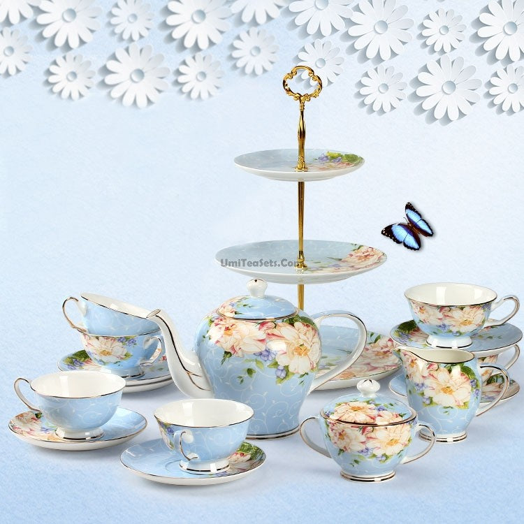 Vintage porcelain tea set with gold trim on a wooden table, showcasing elegant cups and teapot for afternoon tea.