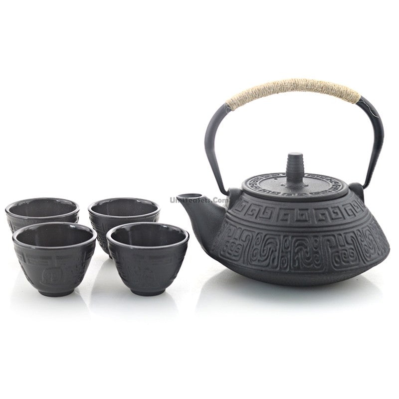 Authentic Japanese cast iron teapot with four cups, showcasing retro design and craftsmanship.