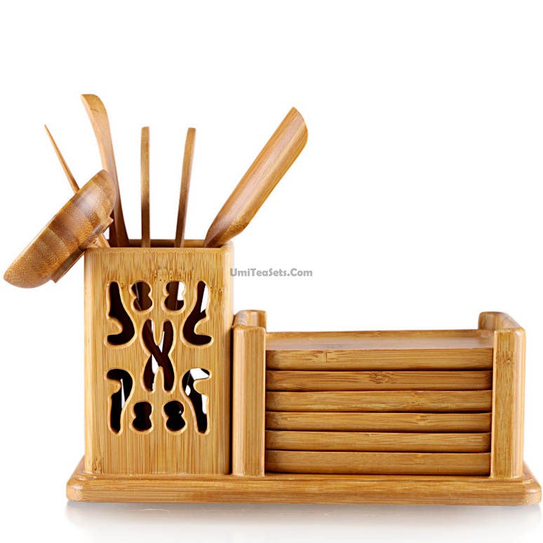Elegant bamboo tea utensil set with cup and saucer placed on a wooden table.