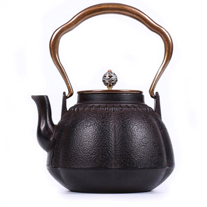 Close-up of Japanese pumpkin cast iron teapot with copper lid and intricate design