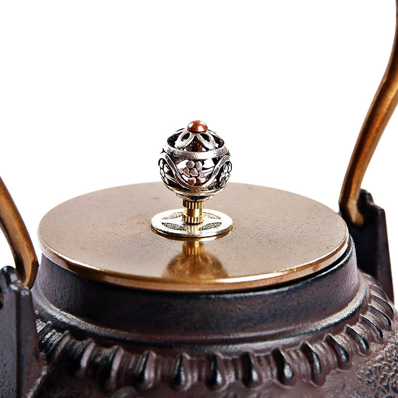 Close-up of Japanese pumpkin cast iron teapot with copper lid and intricate design